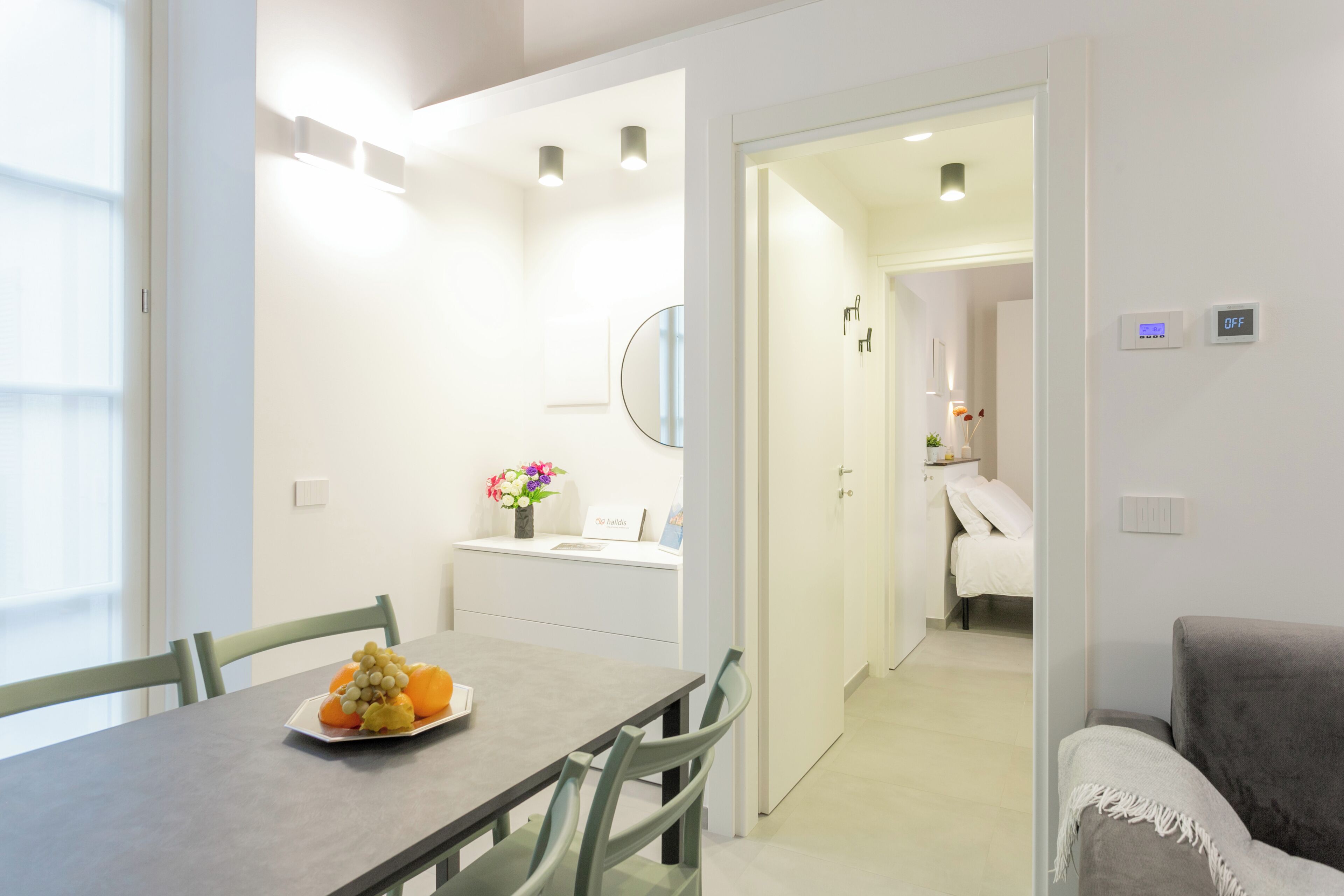 A modern hotel room with a dining area, a bed, and a bathroom.