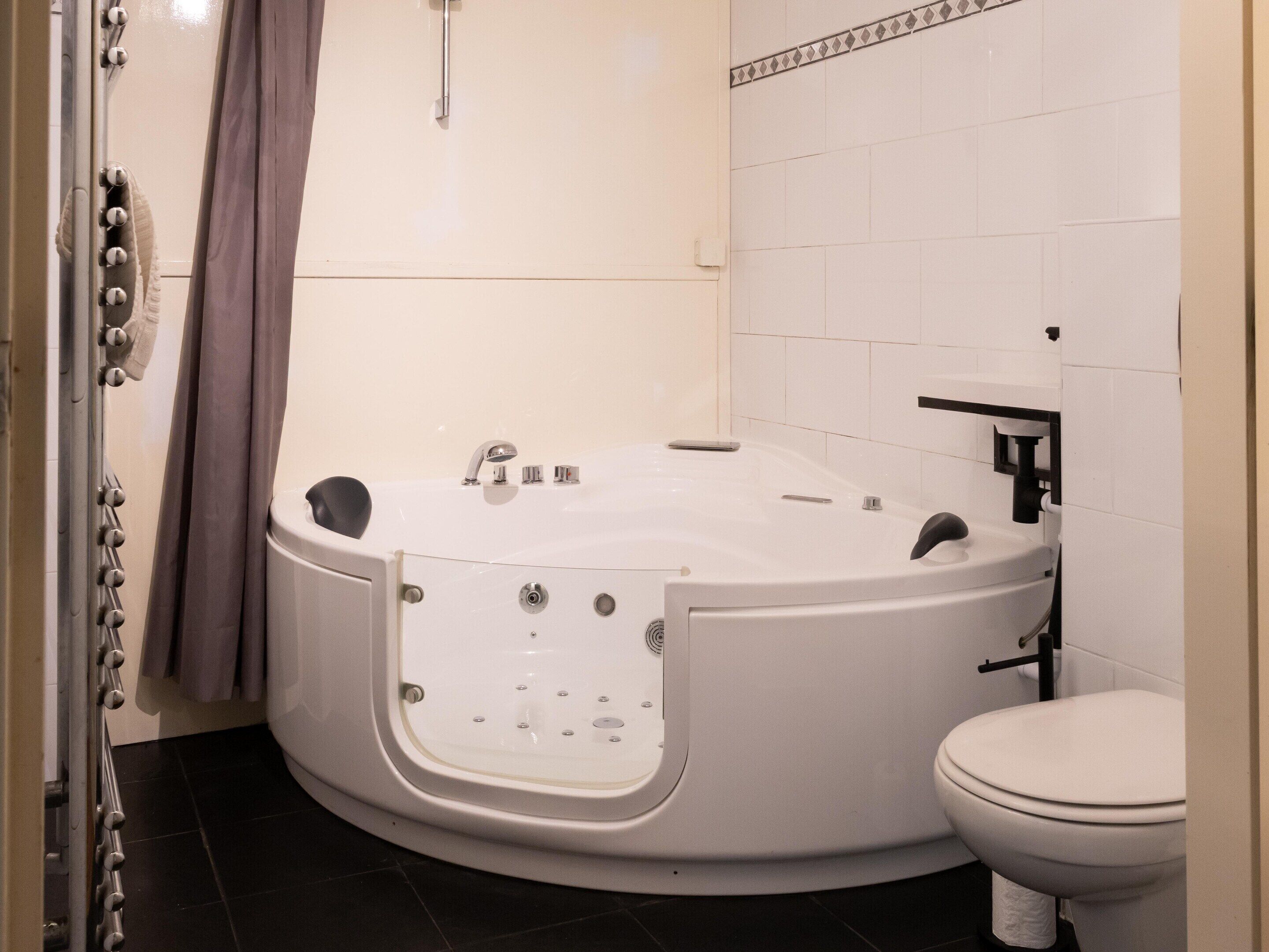 Un baño moderno con una bañera independiente, inodoro y zona de ducha.