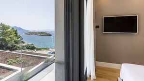 Een moderne kamer met een groot raam, met uitzicht op de zee en een klein eiland.