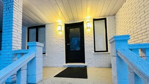 A white brick building with a black door, two windows, and a blue railing. - Cozy Modern 3BR With Free Parking Fast Wifi (Richmond Hill)