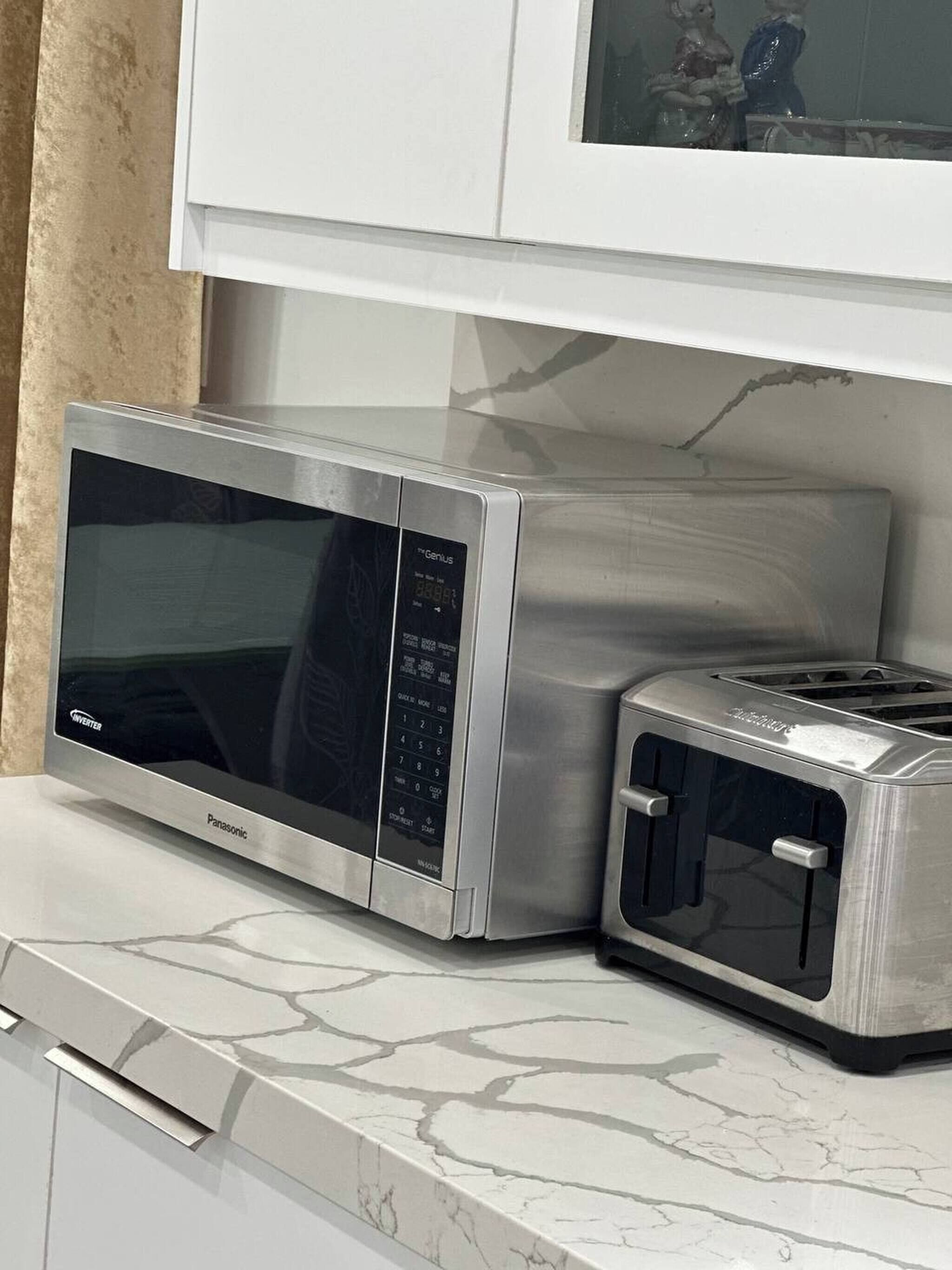 A kitchen with a microwave, toaster, and cabinets.