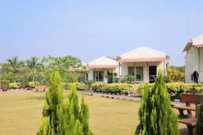 A resort with multiple buildings, a well-maintained lawn, and various plants. - Vanray Farm And Resort (Talala)