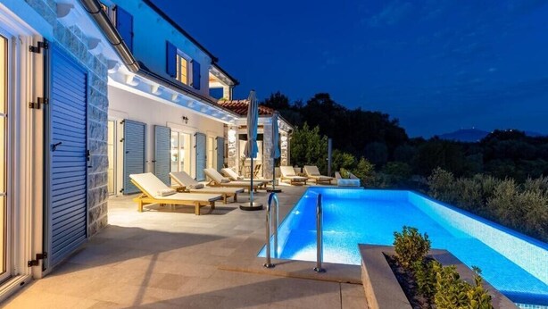 A poolside area with lounge chairs and a swimming pool. - Luxury Villa Blue Dream (Đenovići)