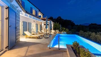 Un espace aménagé au bord de la piscine, avec des chaises longues et une piscine.