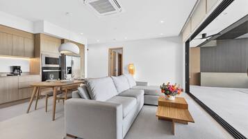 Ein moderner Wohnraum mit Sofa, Esstisch und Küchenzeile.