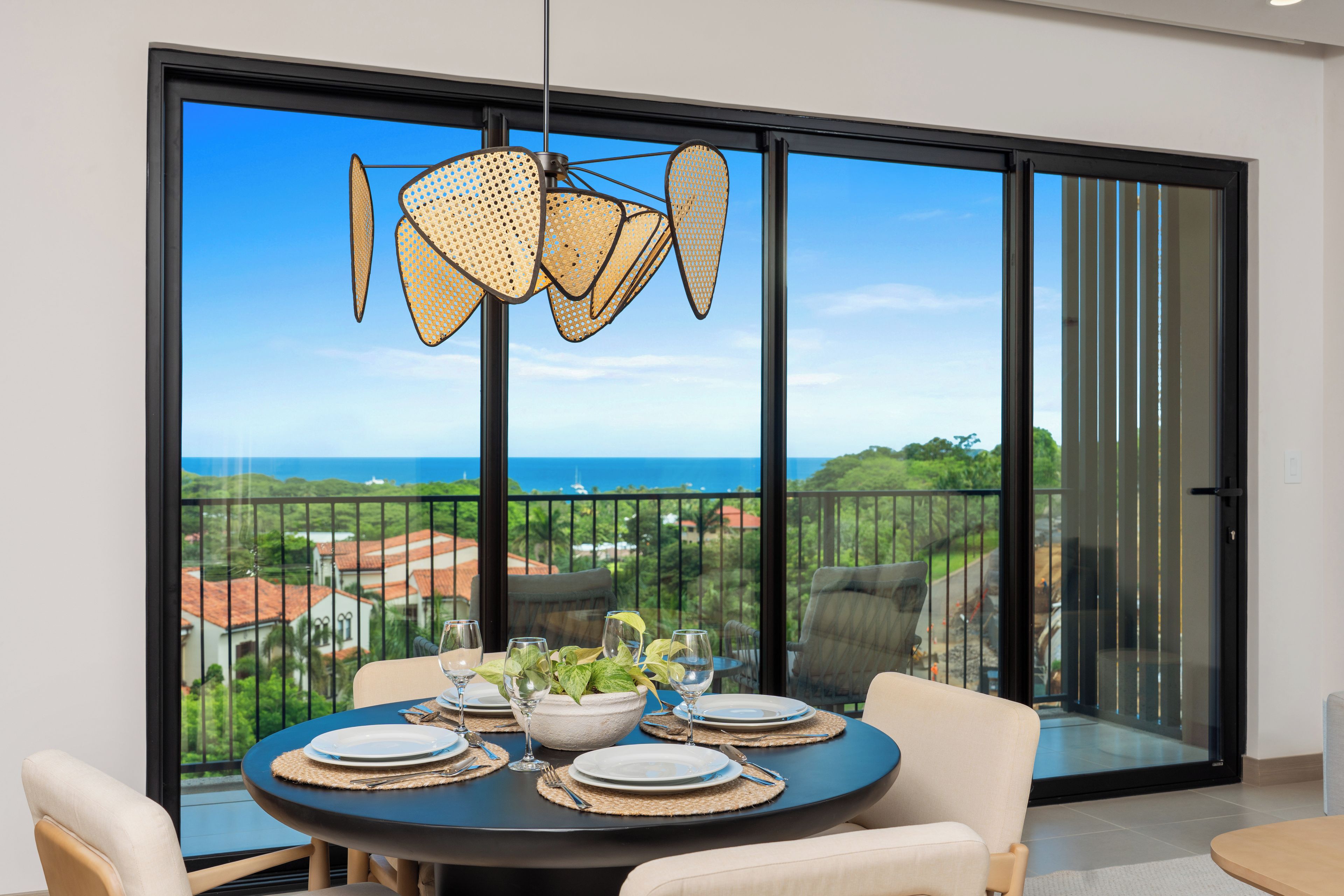 Comedor con una mesa lista para cuatro personas, con vistas panorámicas y un balcón.