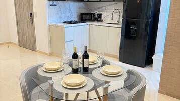 A modern kitchen with a black refrigerator, a microwave, and a gas stove.
