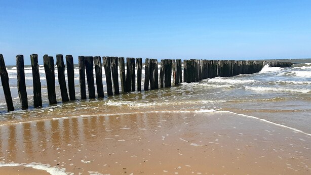 A beach with a wooden breakwater and waves crashing onto the shore. - Gîte rural Le Vent du Nord – Ferme des 4 Vents (Audinghen)