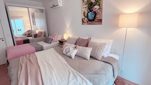 Ein Schlafzimmer mit einem großen Bett, einem Nachttisch, einer Lampe und einem Bild an der Wand.