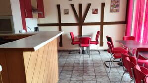 A restaurant interior with a counter, red chairs, and a tiled floor. - Accommodation for up to 25 people / from 15-per person (Waldbronn)