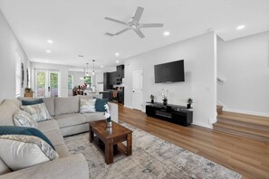 Ein modernes Wohnzimmer mit einer Couch, einem Couchtisch und einer TV-Bank.