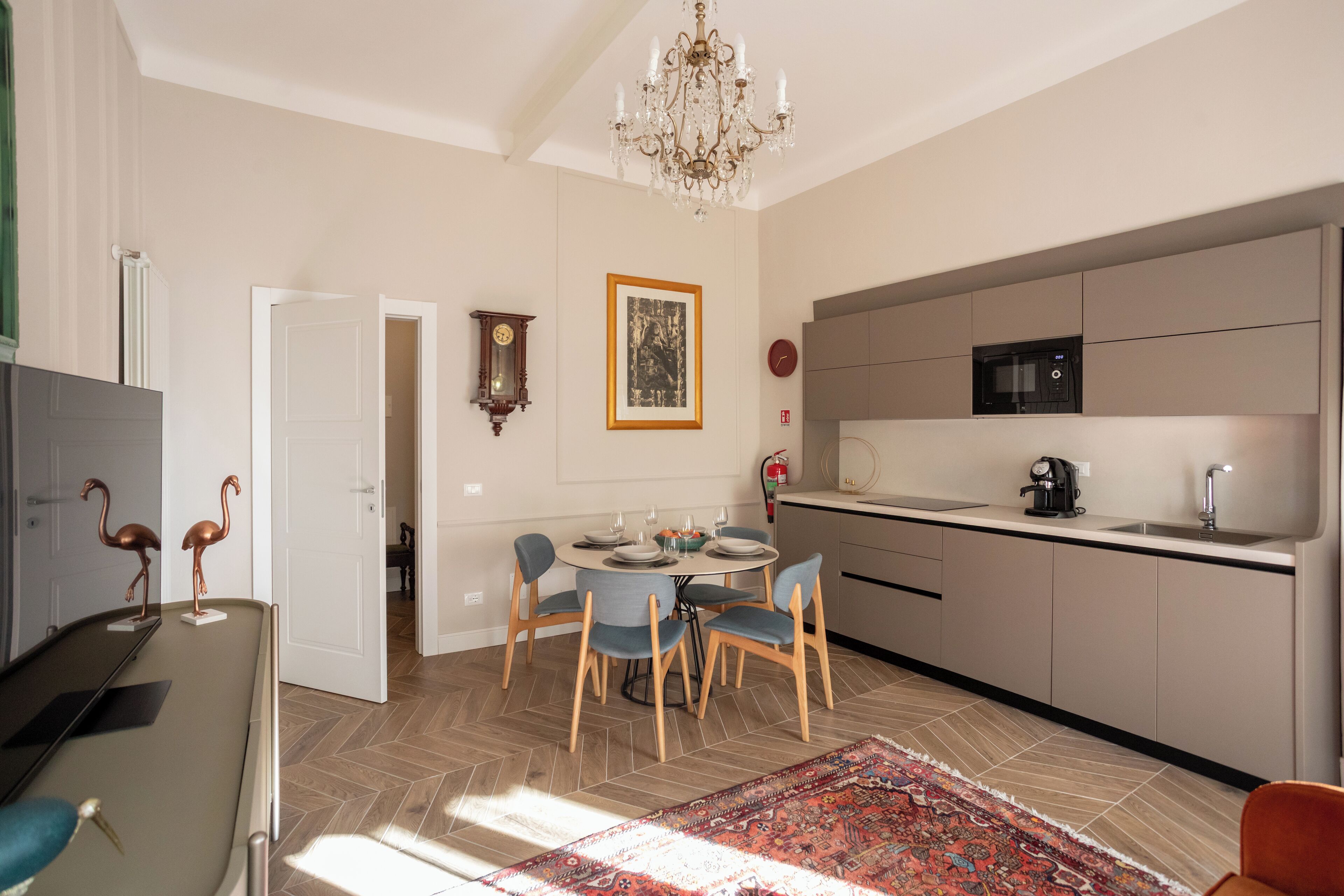 Una cucina moderna con forno a microonde, lavello e zona pranzo con sedie e tavolo.