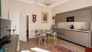 Una cocina moderna con microondas, pileta y comedor con sillas y una mesa.