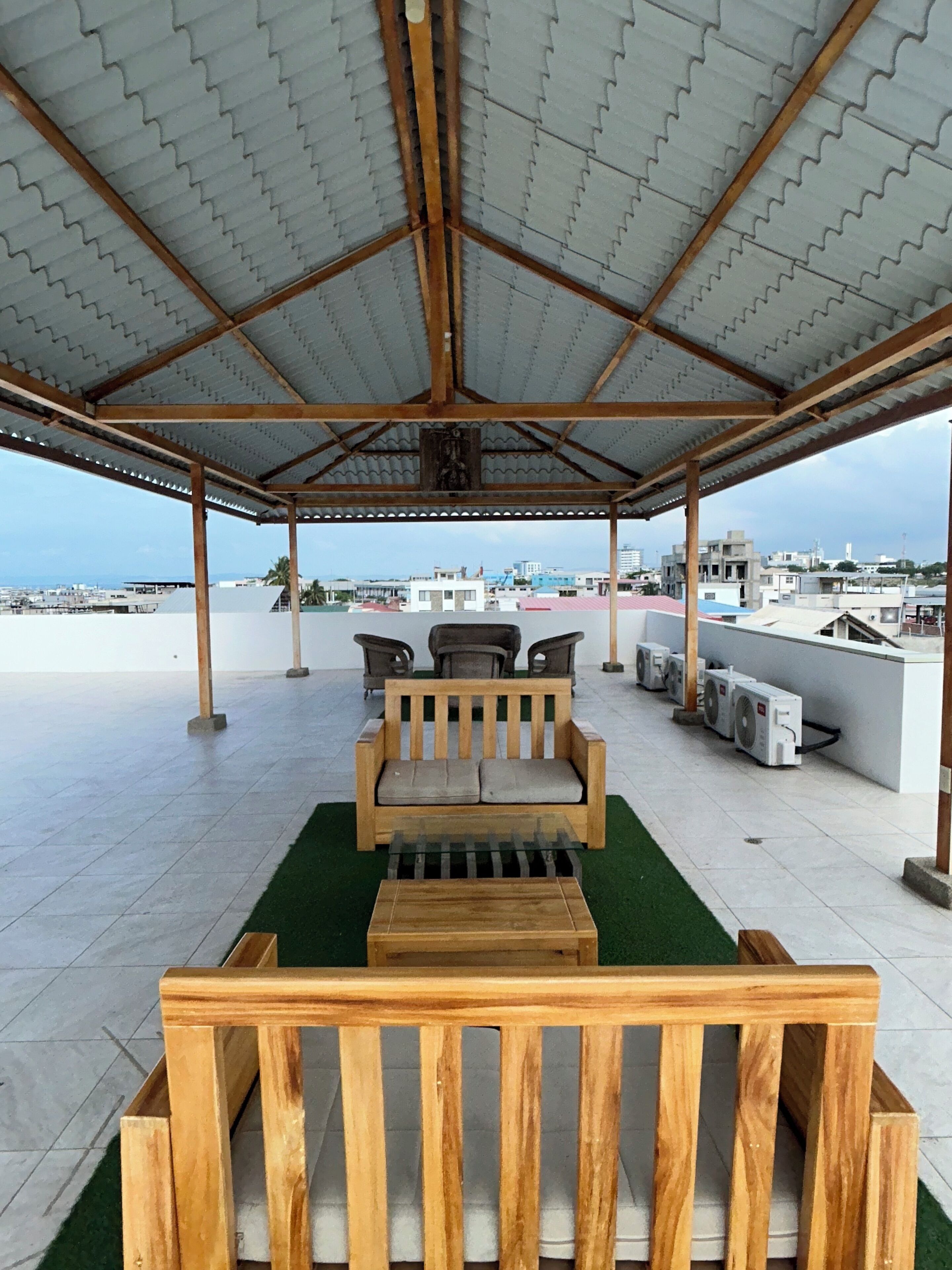 A covered outdoor seating area with a view of the cityscape.