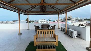 A covered outdoor seating area with a view of the cityscape.