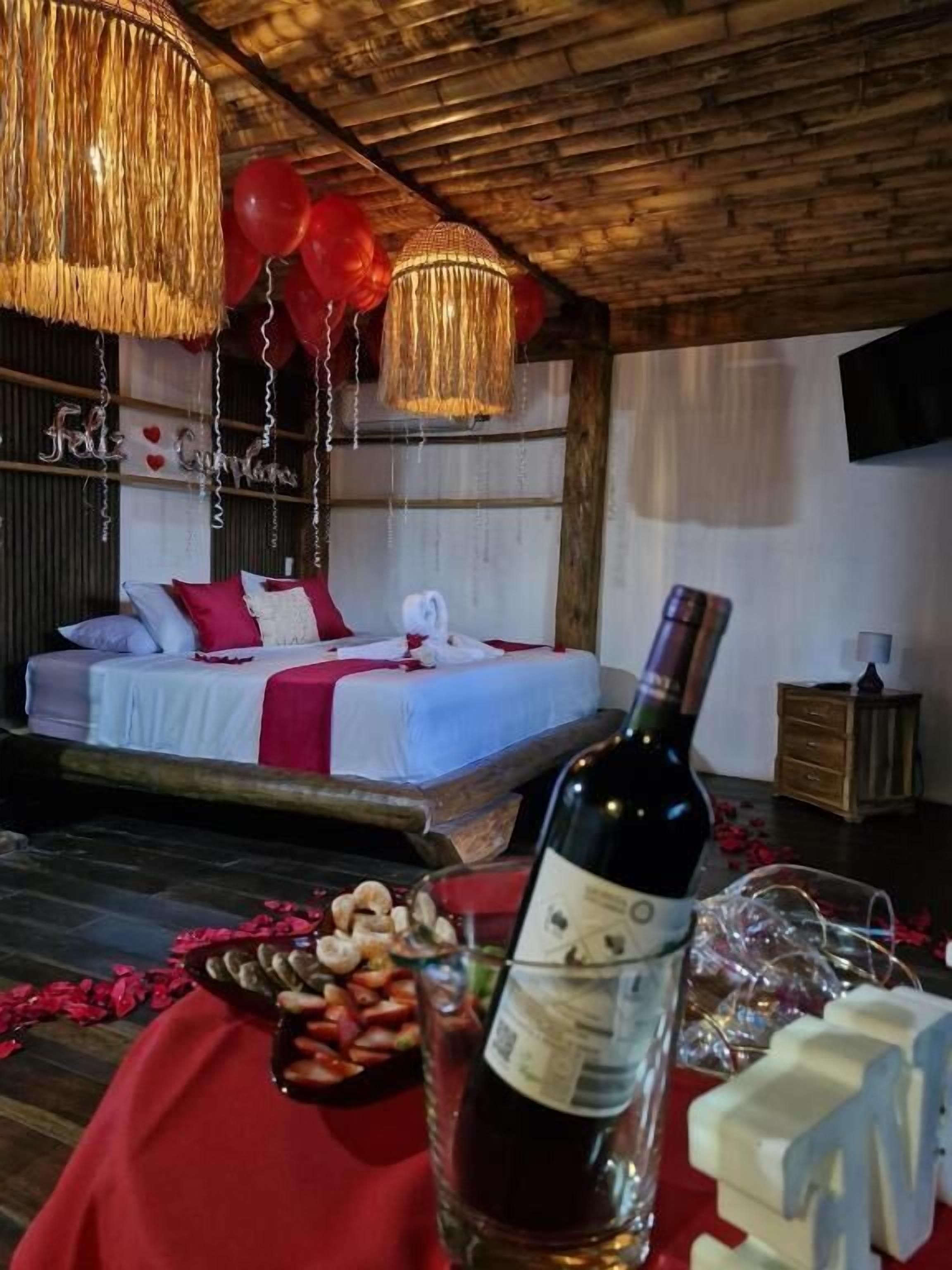 Ein gemütliches Schlafzimmer mit einem Bett, einem Nachttisch und einer Weinflasche.