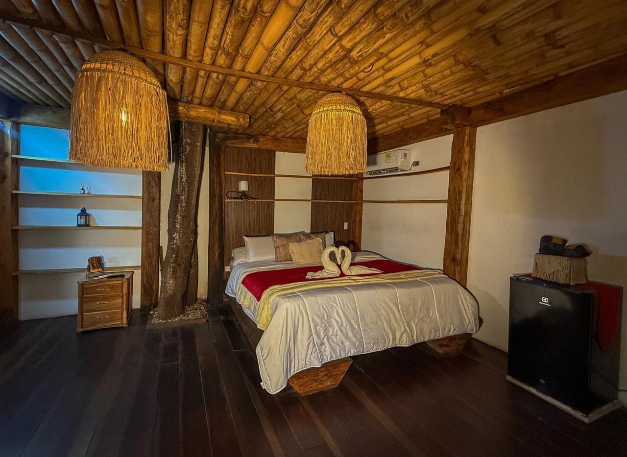 Une pièce avec un lit, des meubles en bois et un plafond avec des poutres apparentes.