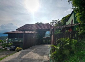 A hotel with a tiled roof, a covered entrance, and a view of the surrounding landscape. - Ecohotel Alflo (Villeta)