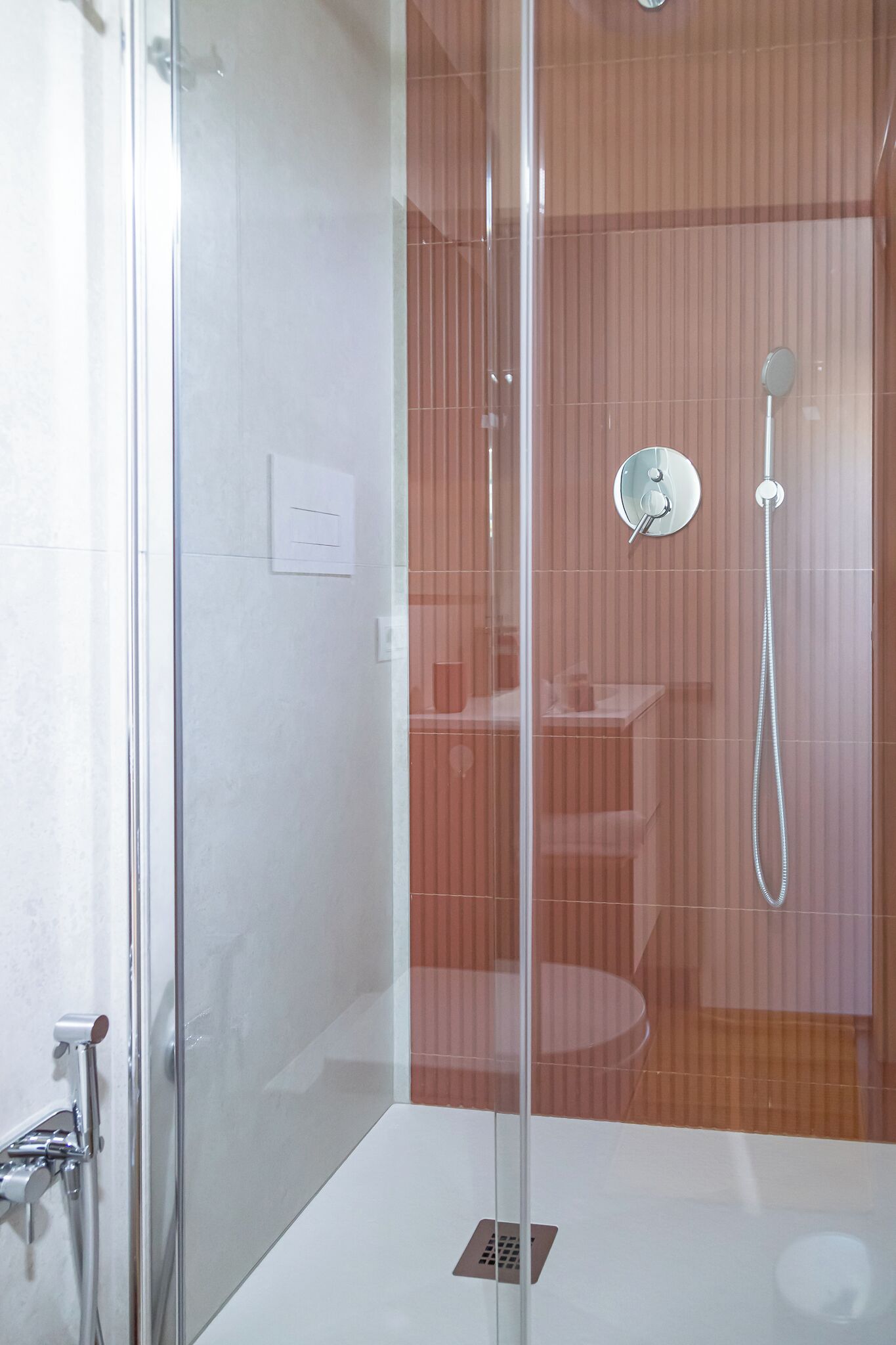 Un baño moderno con ducha acristalada, inodoro a la vista y zona de lavamanos.