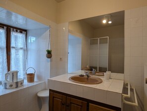 A bathroom with a sink, mirror, toilet, and window with curtains. - Old farmhouse with stunning views - 4 guests (Polignac)