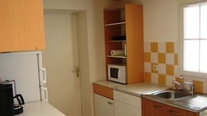 Eine kleine Küche mit Mikrowelle, Spüle und Holzschränken.