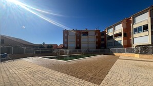A courtyard with a swimming pool, a paved walkway, and a multi-story building with balconies. - Cozy house with AC and parking - 6 guests (Argelès-sur-Mer)