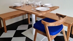 A dining table with white plates, glasses, and cutlery, and a blue cushioned chair. - House with private pool - 4 guests (Saint-Joseph)