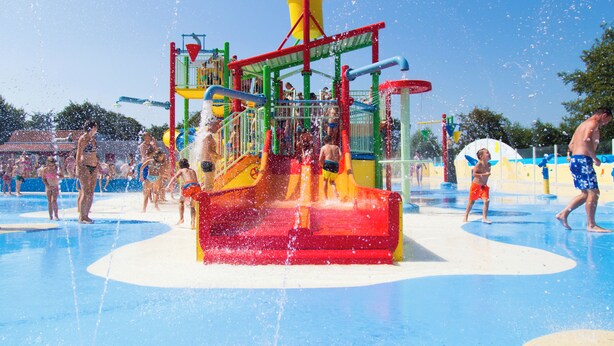 Ein Wasserpark mit einer zentralen Wasserrutsche und mehreren Spielbereichen.