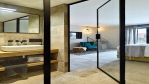 Un baño moderno con un espejo grande, un lavamanos blanco y un mueble de tocador de madera.