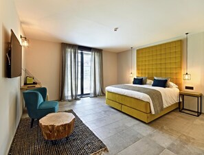 Een moderne slaapkamer met een groot bed, een bureau en een stoel.