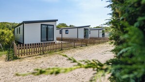A row of mobile homes with a wooden fence in front. - Duinhoeve chalet Schelp (Burgh-Haamstede)