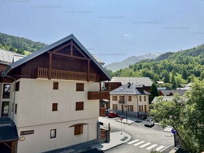 Ein traditionelles Chalet mit geneigtem Dach und Holzbalkon, gelegen in einer Bergregion mit freiem Blick auf die umliegende Landschaft.