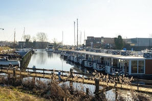 Un port de plaisance avec des bateaux amarrés, une jetée en bois et un bâtiment en arrière-plan.