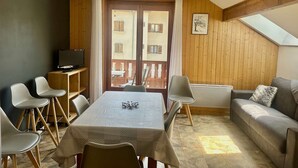 A cozy room with a dining table, chairs, a sofa, and a TV. - Family apartment - 6 guests (Valloire)