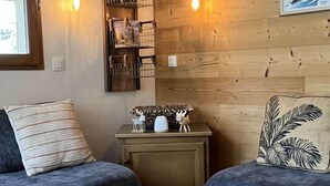 A cozy living room with two sofas, a small wooden cabinet, and a decorative wall shelf. - Cozy apartment, parking, pets welcome - 6 guests (Valloire)