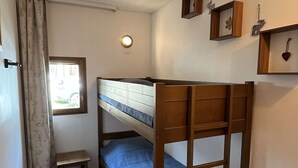 A bunk bed room with a window, a small table, and wall decorations. - Cozy apartment, parking, pets welcome - 6 guests (Valloire)