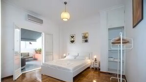 A modern bedroom with a large bed, a bedside table, a hanging light fixture, and a white wardrobe. - Athens Central Jacuzzi Retreat (Athens)