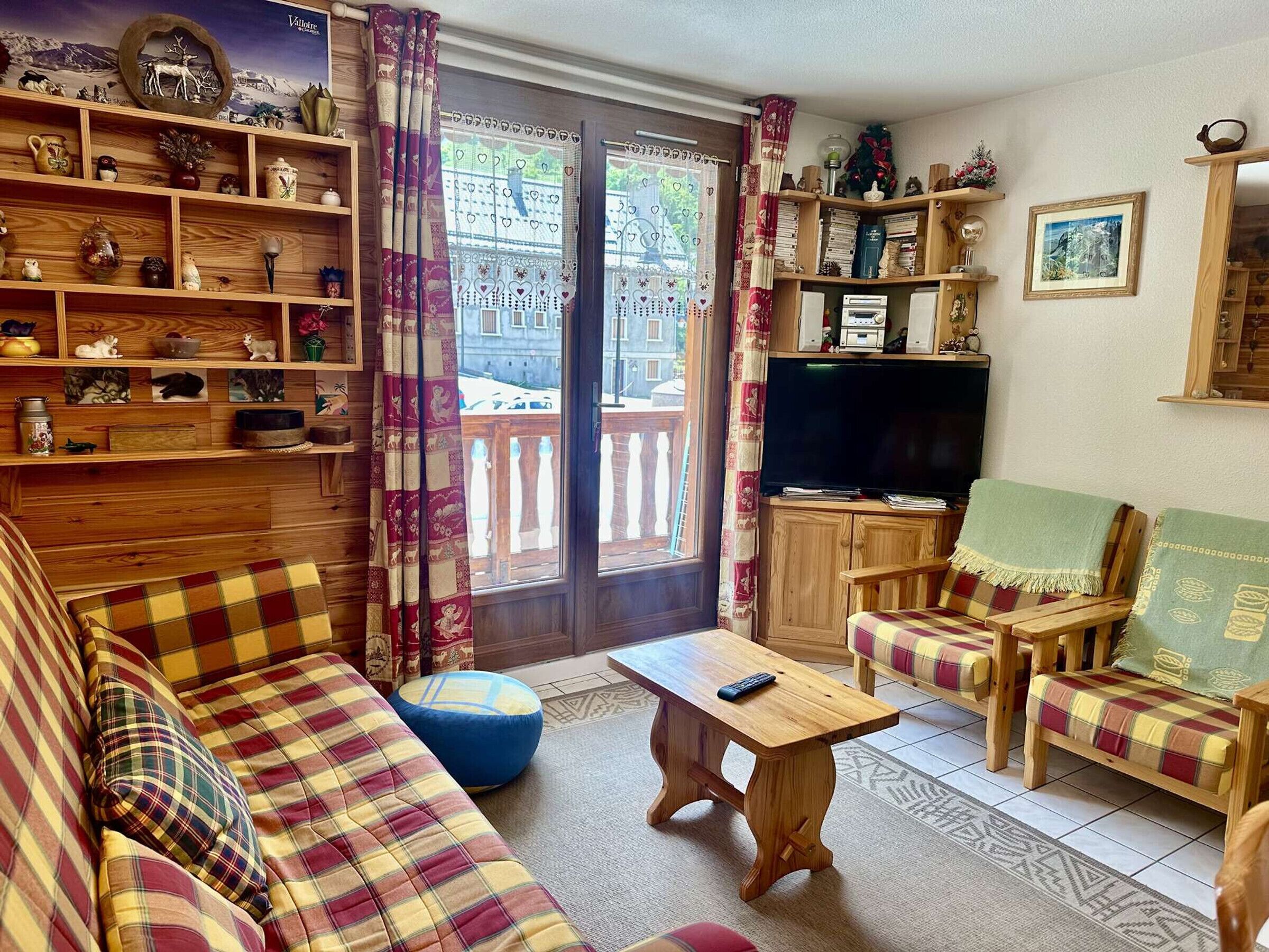 Un salon confortable avec un canapé, des fauteuils, une table basse et un téléviseur.
