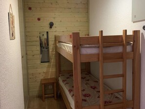 A small, wooden room with bunk beds, a small table, and a mirror on the wall. - Functional studio with cabin - 4 guests (Valloire)
