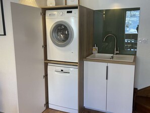 A compact laundry area with a Bosch washing machine and a dishwasher, a small sink, and a mirror above the sink. - Duplex apartment with parking - 8 guests (Valloire)