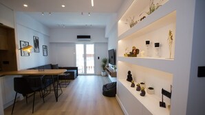Un espace de vie moderne comprenant une cuisine, un coin repas et un couloir menant à un balcon.