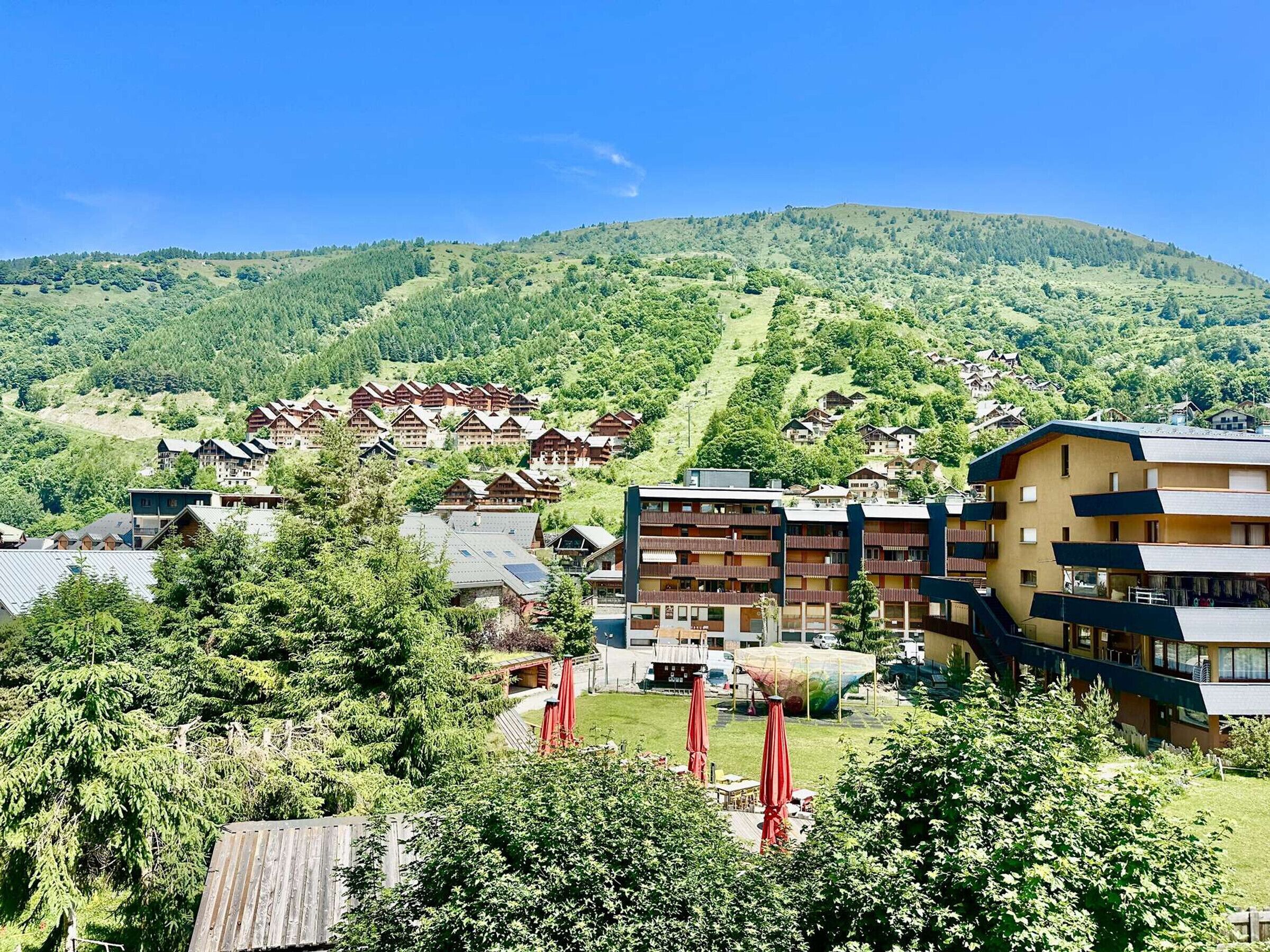 Ein Bergresort mit Chalet-ähnlichen Lodges, einem zentralen Gebäude mit Balkonen und freiem Blick auf die umliegenden Hügel.