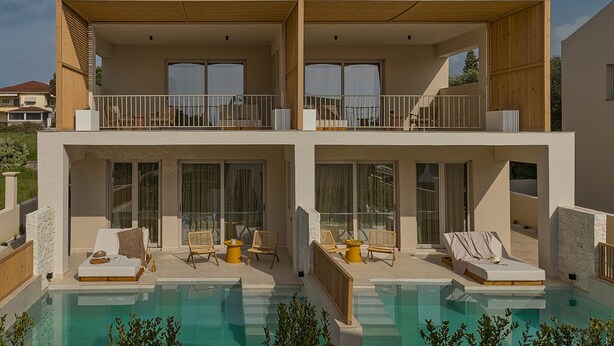 Une maison moderne à deux étages dotée d’une piscine, de balcons et d’un espace salon extérieur.