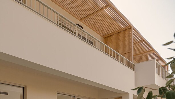 A modern outdoor pool area with lounge chairs, a small table, and a staircase leading to a second-floor balcony. - Luxury Suite with Private Pool by Kiva (Mitikas)