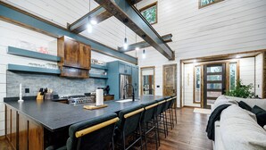 Una cocina amplia con una isla grande, vigas de madera y vistas al exterior.