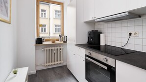 A modern kitchen with a window, a coffee maker, and an oven. - Grand Apartment close to the Isar and Citycenter (München)