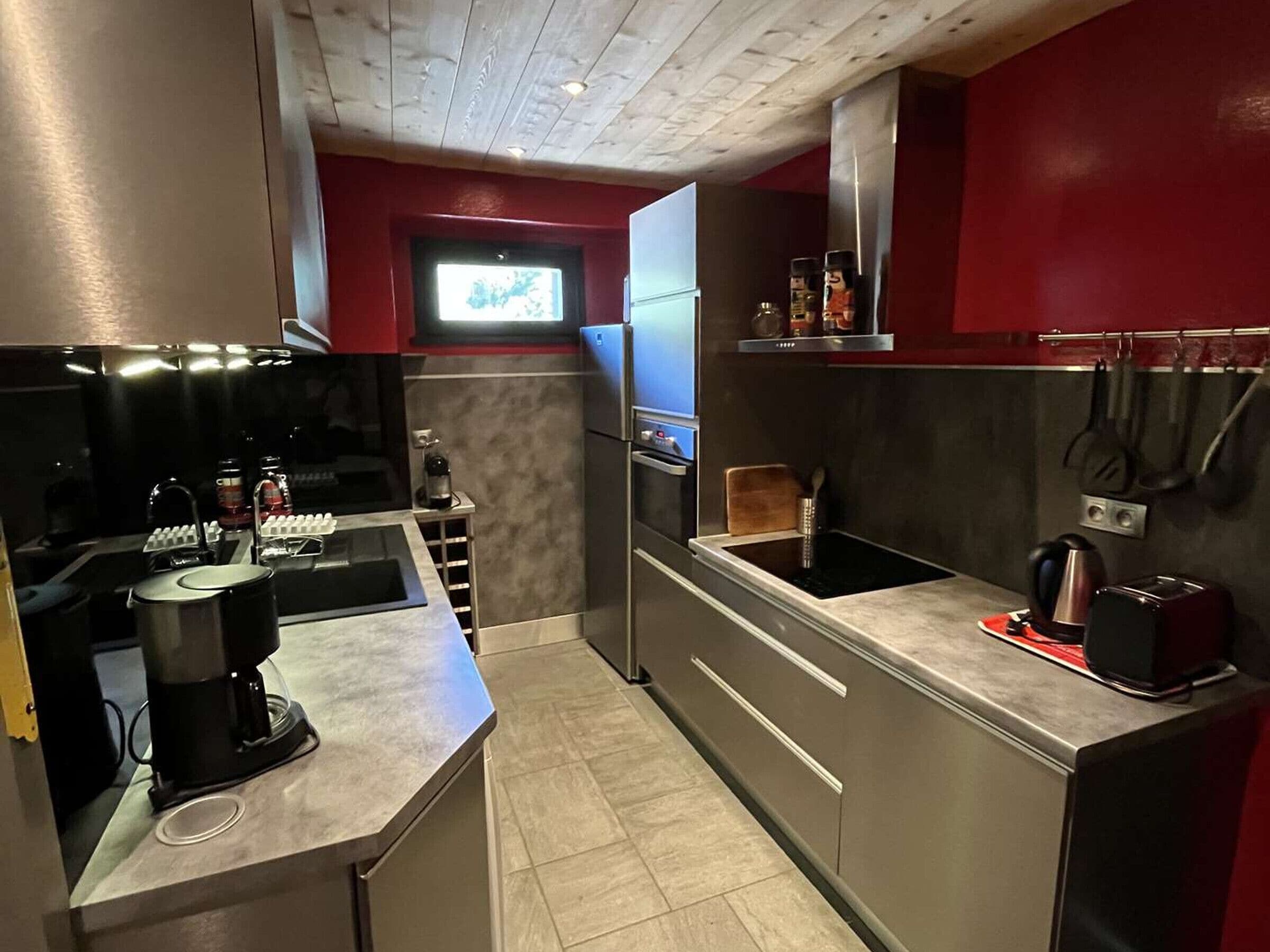 Een kleine keuken met een inbouwmagnetron, een koffiezetapparaat en een broodrooster.