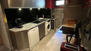A compact kitchen with stainless steel appliances, a washing machine, and a toaster. - Spacious apartment with balcony - 7 guests (Valloire)