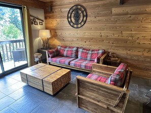 A wooden interior with a sofa and a coffee table. - Spacious apartment with balcony - 7 guests (Valloire)