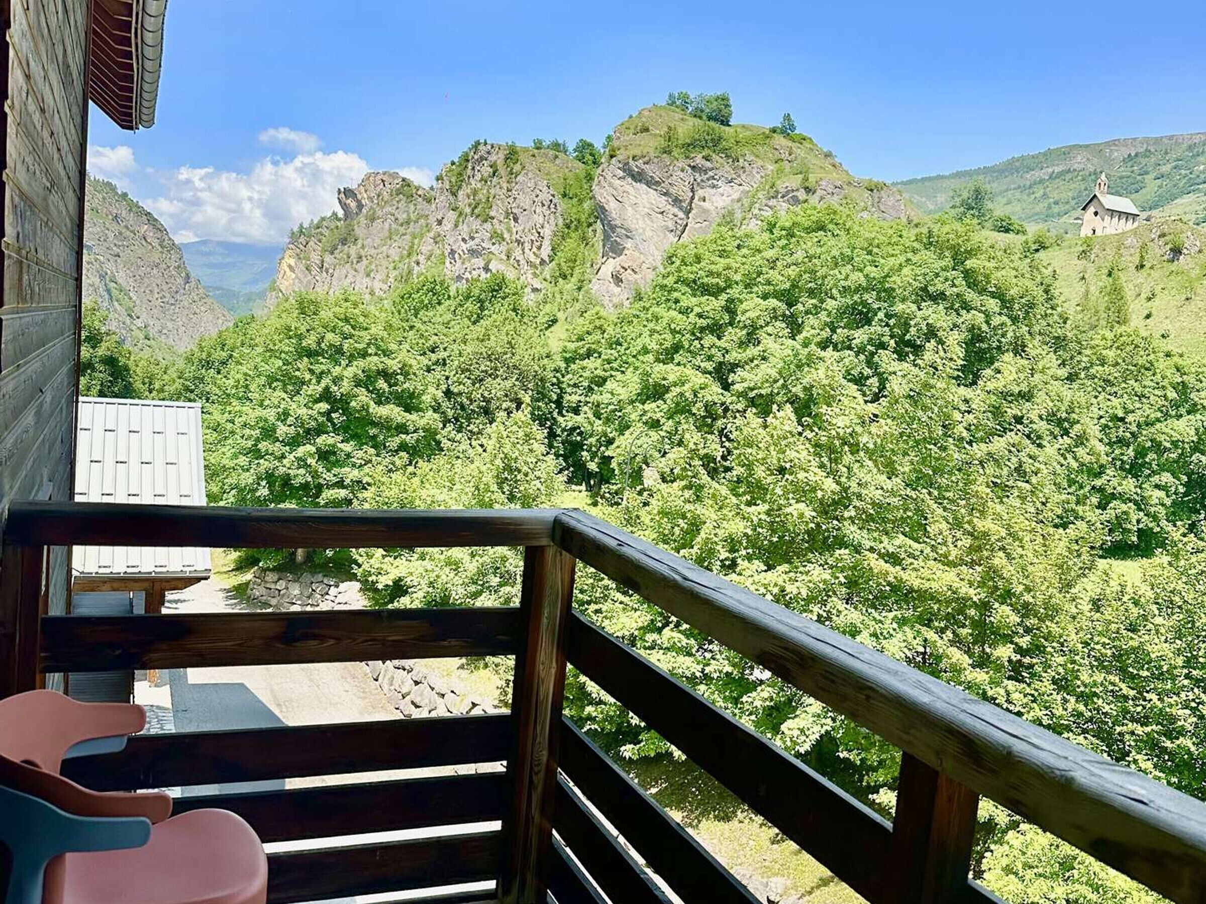 A wooden balcony with a view of a mountainous landscape.